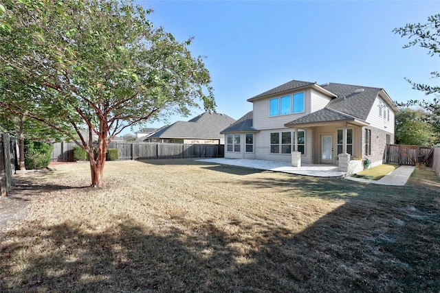 back of house featuring a patio and a yard