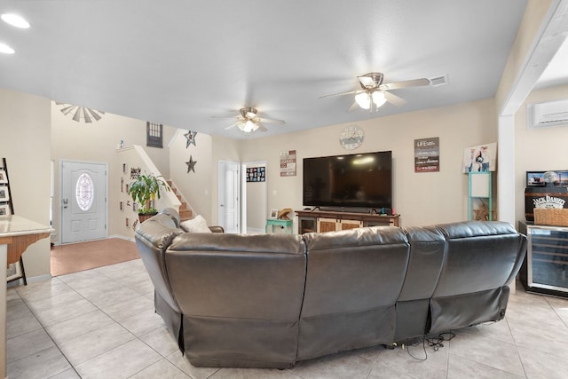 living room with a wall unit AC, ceiling fan, and light tile patterned floors