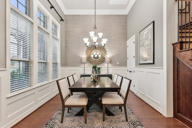 dining space with a chandelier, crown molding, and wood-type flooring