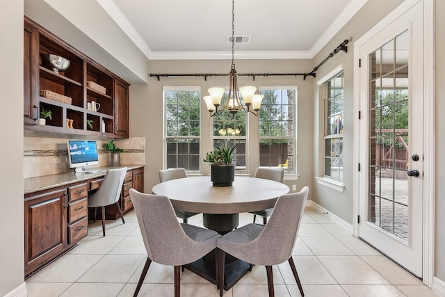 dining area with built in desk, crown molding, an inviting chandelier, and light tile patterned floors