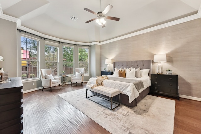 bedroom with dark wood-type flooring, crown molding, and ceiling fan