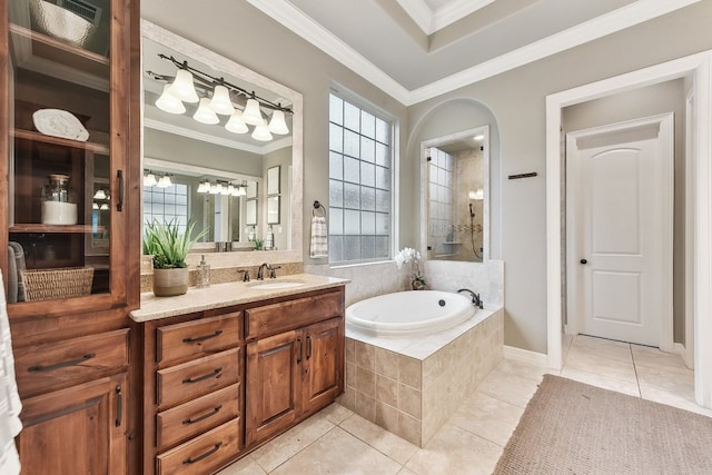 bathroom featuring vanity, a relaxing tiled tub, ornamental molding, and tile patterned flooring