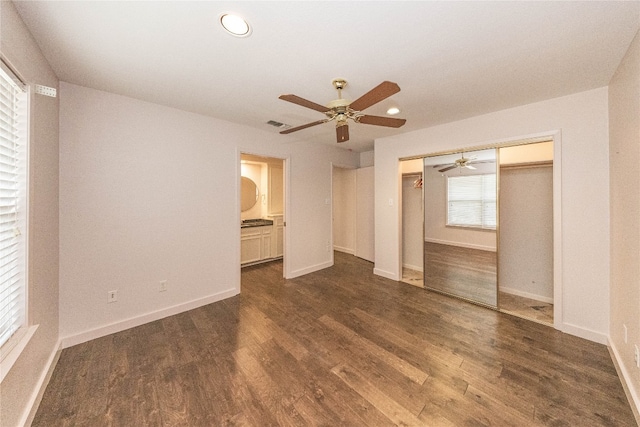 unfurnished bedroom featuring ceiling fan, dark hardwood / wood-style floors, and a closet