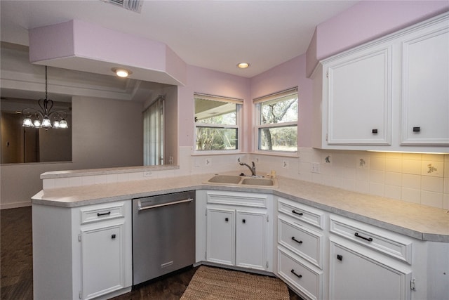 kitchen featuring sink, kitchen peninsula, stainless steel dishwasher, hanging light fixtures, and white cabinets