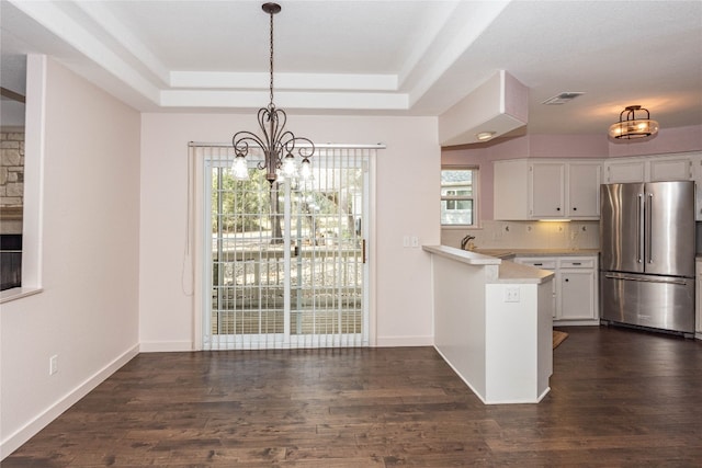 kitchen with white cabinetry, high end refrigerator, decorative light fixtures, dark wood-type flooring, and kitchen peninsula