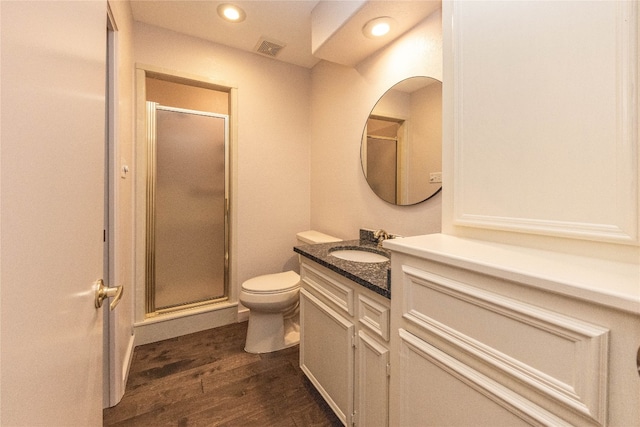 bathroom featuring hardwood / wood-style flooring, vanity, toilet, and an enclosed shower