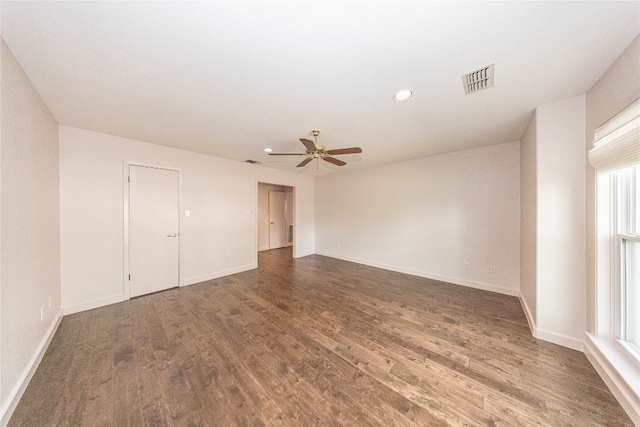 spare room with ceiling fan, a wealth of natural light, and dark hardwood / wood-style floors