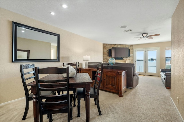 carpeted dining area with a textured ceiling and ceiling fan