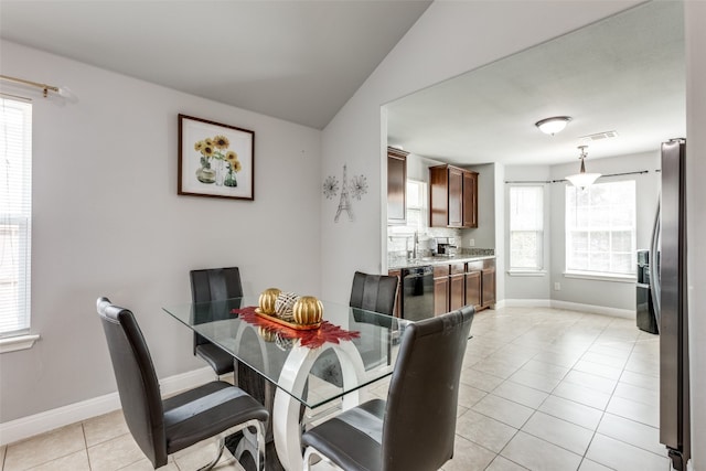 dining room with vaulted ceiling and light tile patterned floors