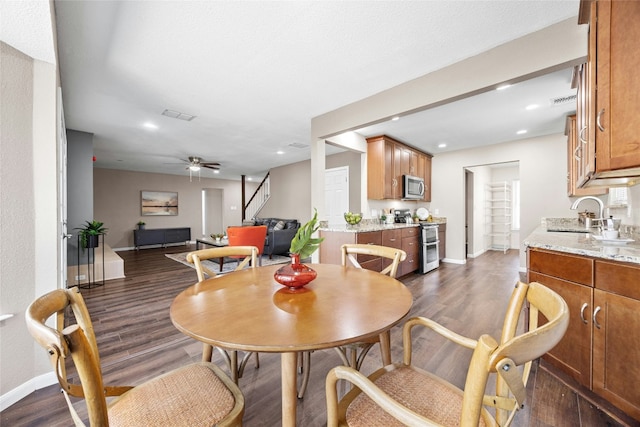 dining room featuring ceiling fan, dark hardwood / wood-style flooring, and sink