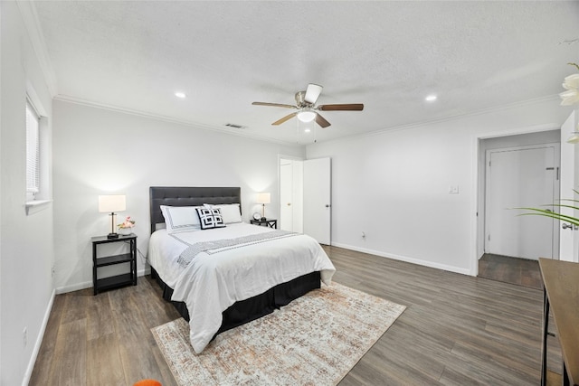 bedroom featuring ceiling fan, dark hardwood / wood-style flooring, crown molding, and a textured ceiling