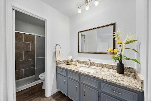 bathroom featuring hardwood / wood-style floors, vanity, toilet, and walk in shower