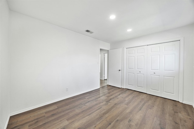 unfurnished bedroom featuring dark hardwood / wood-style floors and a closet