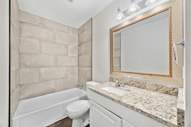 full bathroom featuring vanity, tiled shower / bath, and toilet