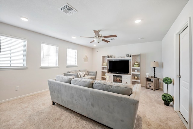 carpeted living room with ceiling fan