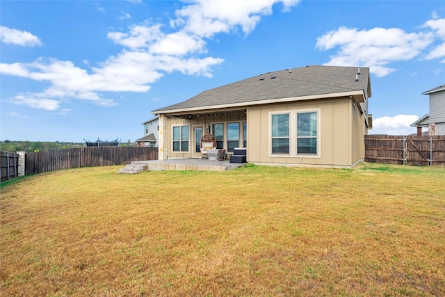 rear view of property featuring a patio and a yard