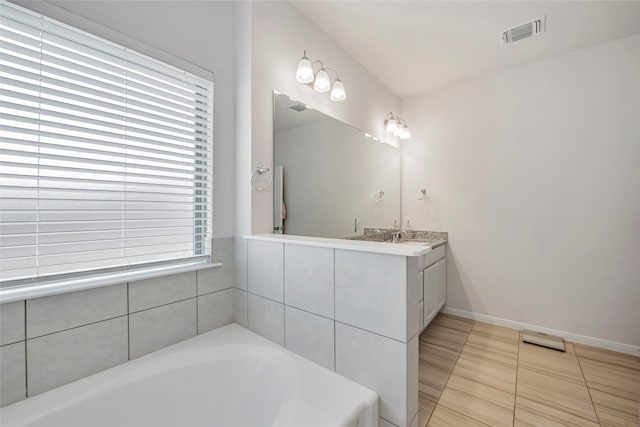 bathroom featuring vanity, tiled tub, and tile patterned floors