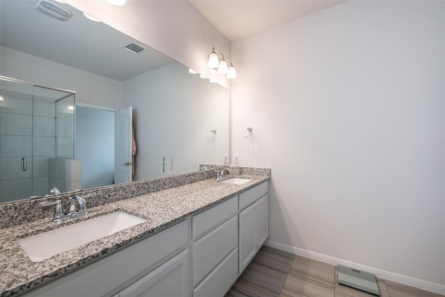 bathroom featuring a shower with door, vanity, and tile patterned floors