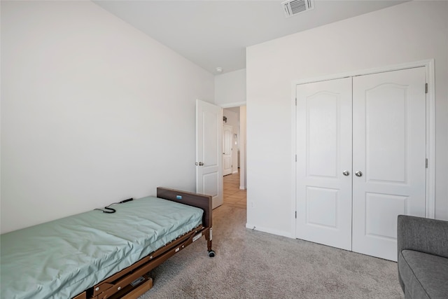 bedroom with light colored carpet and a closet