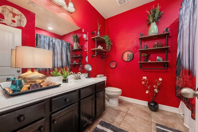 bathroom with vanity, toilet, and tile patterned flooring