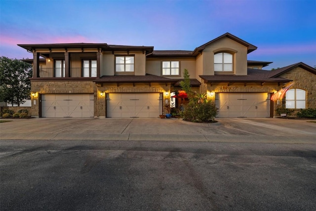 335 Lombardia Dr Unit 19E, Austin, TX 78734 - view of front of house with an attached garage, driveway, stone siding, and stucco siding