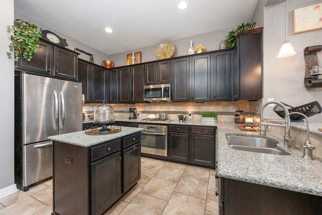 kitchen with dark brown cabinets, stainless steel appliances, backsplash, sink, and a center island