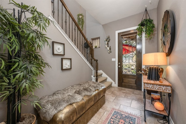 tiled foyer with lofted ceiling