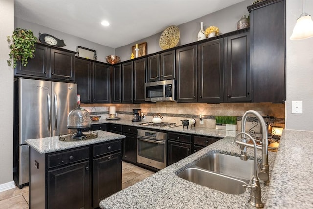 335 Lombardia Dr Unit 19E, Austin, TX 78734 - kitchen with pendant lighting, light stone countertops, tasteful backsplash, a sink, and appliances with stainless steel finishes
