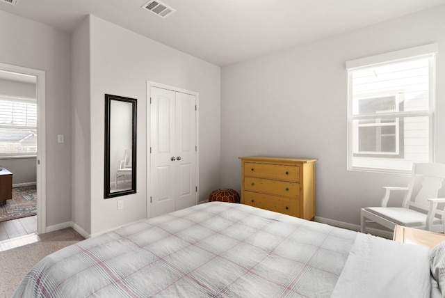 bedroom featuring light carpet and a closet