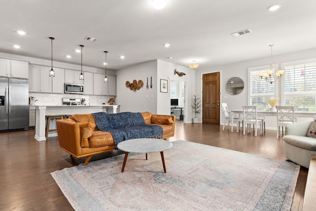 living room with dark hardwood / wood-style flooring and a notable chandelier