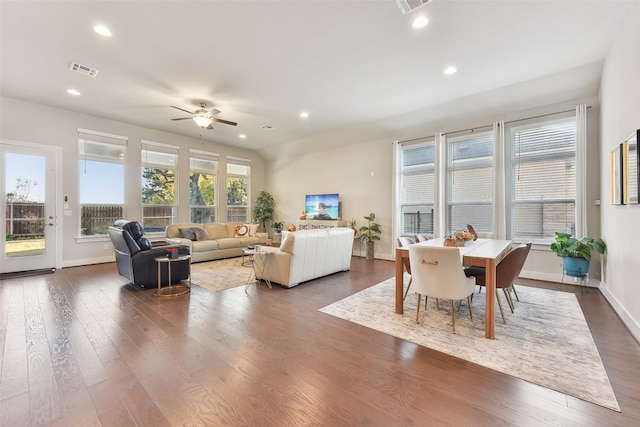 living room featuring dark wood-type flooring and ceiling fan