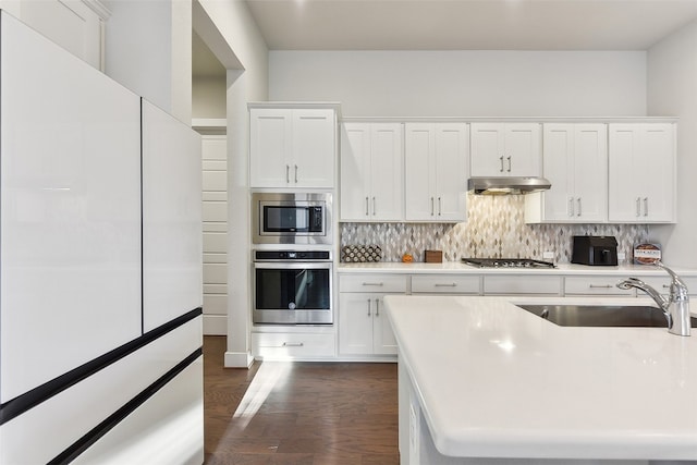 kitchen featuring tasteful backsplash, appliances with stainless steel finishes, white cabinetry, dark wood-type flooring, and sink