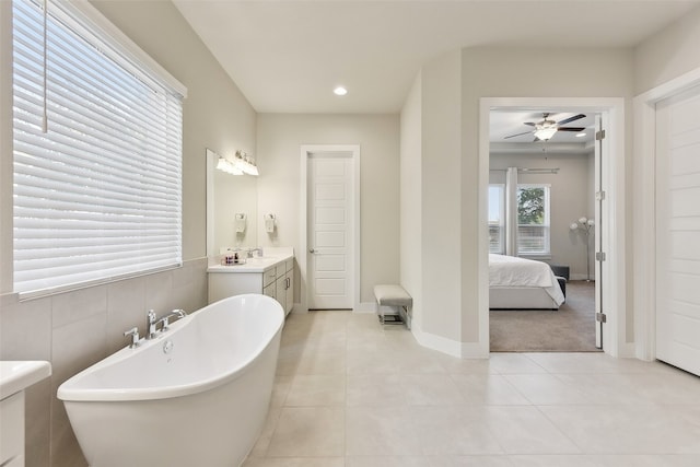 bathroom with vanity, ceiling fan, a tub to relax in, and tile patterned flooring