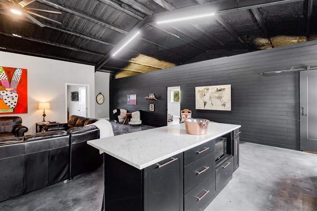 kitchen featuring a kitchen island, black microwave, and concrete floors