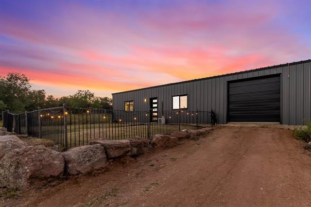 gate at dusk featuring an outdoor structure