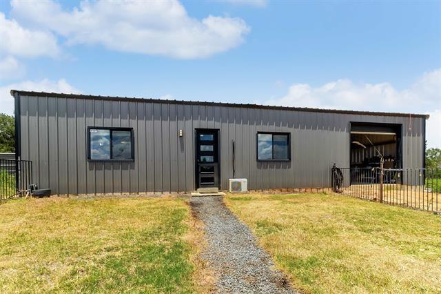 view of front facade featuring an outbuilding and a front lawn