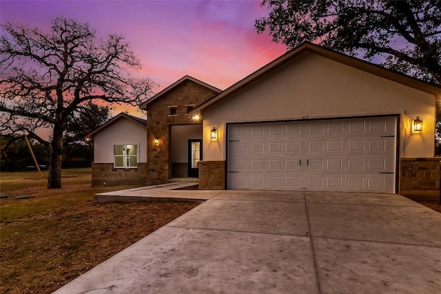 427 E Castleshoals Dr, Granite Shoals, TX 78654 - view of front of property featuring stone siding, a garage, concrete driveway, and stucco siding