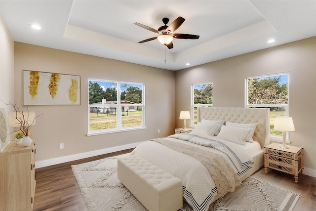 427 E Castleshoals Dr, Granite Shoals, TX 78654 - bedroom featuring a raised ceiling, recessed lighting, baseboards, wood finished floors, and a ceiling fan
