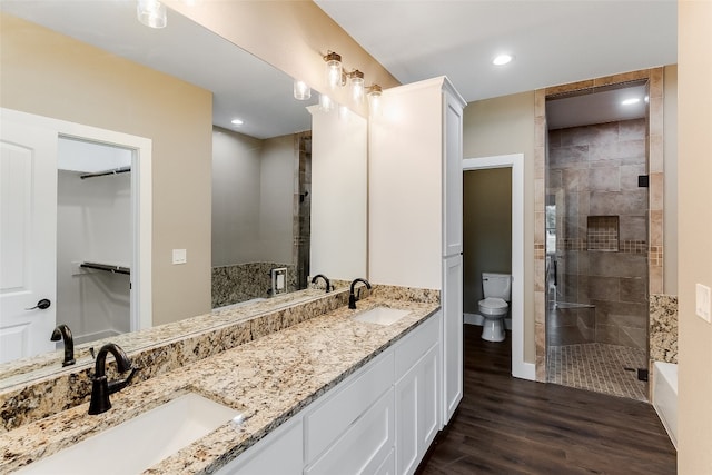 bathroom featuring vanity, hardwood / wood-style floors, toilet, and walk in shower