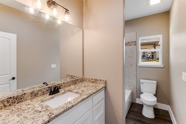 full bathroom featuring toilet, tiled shower / bath combo, hardwood / wood-style flooring, and vanity