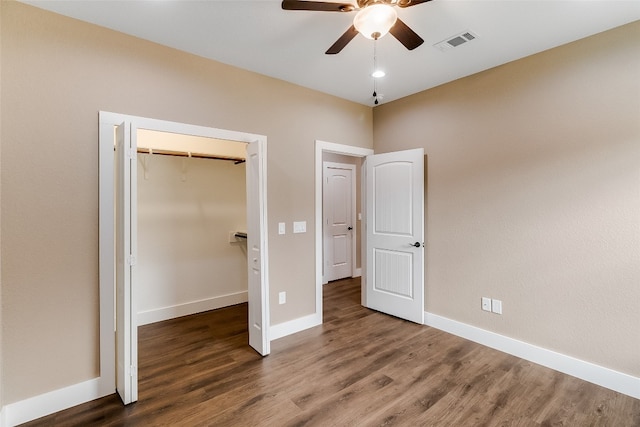 unfurnished bedroom featuring dark wood-type flooring, ceiling fan, and a closet