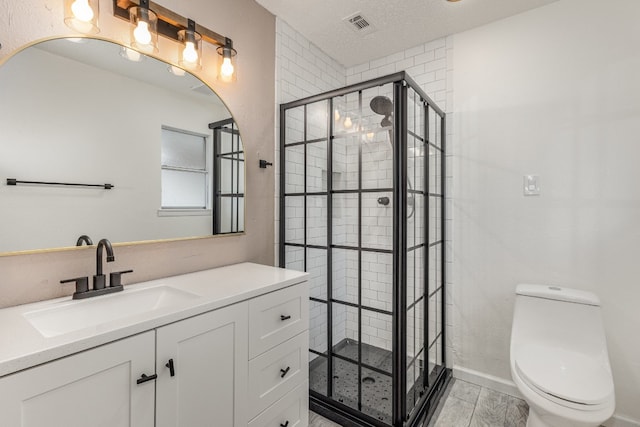 bathroom featuring a textured ceiling, hardwood / wood-style floors, toilet, walk in shower, and vanity