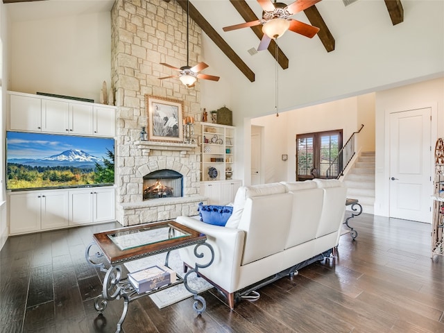 living room with wood-type flooring, a fireplace, ceiling fan, beamed ceiling, and high vaulted ceiling