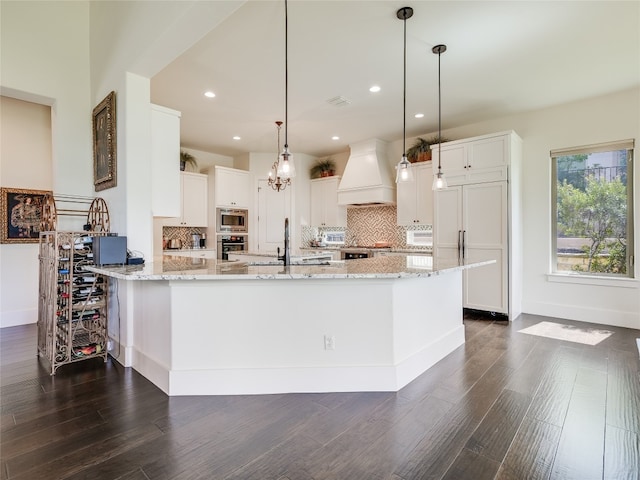 kitchen featuring custom exhaust hood, dark hardwood / wood-style floors, built in appliances, and white cabinetry