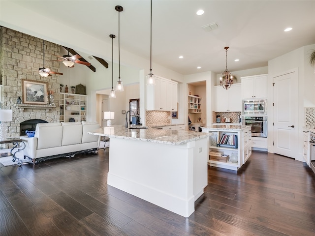 kitchen featuring a spacious island, white cabinets, stainless steel appliances, and dark hardwood / wood-style flooring