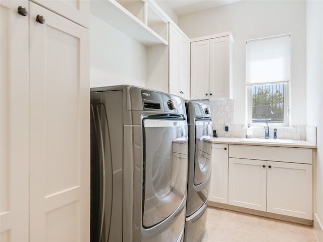 laundry room with cabinets, sink, and separate washer and dryer