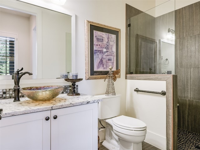 bathroom featuring toilet, hardwood / wood-style floors, walk in shower, and vanity