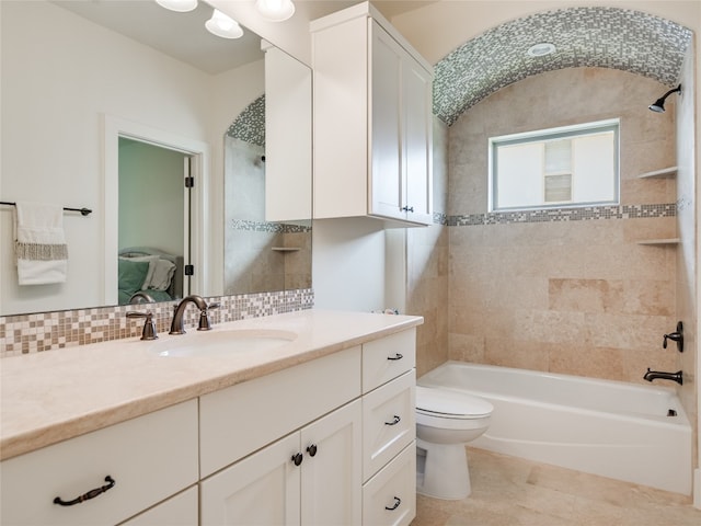 full bathroom featuring tiled shower / bath, vanity, toilet, and tile patterned floors