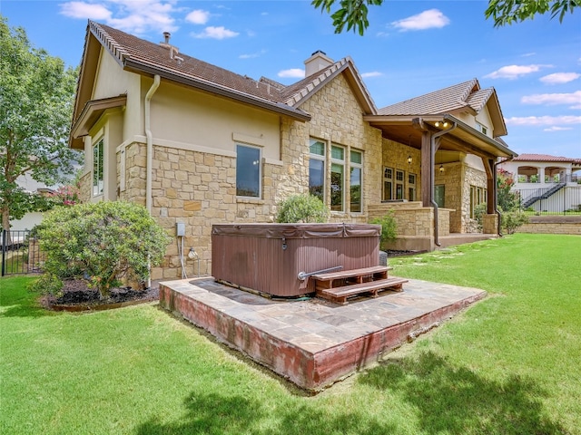 back of house featuring a hot tub, a patio area, a yard, and ceiling fan