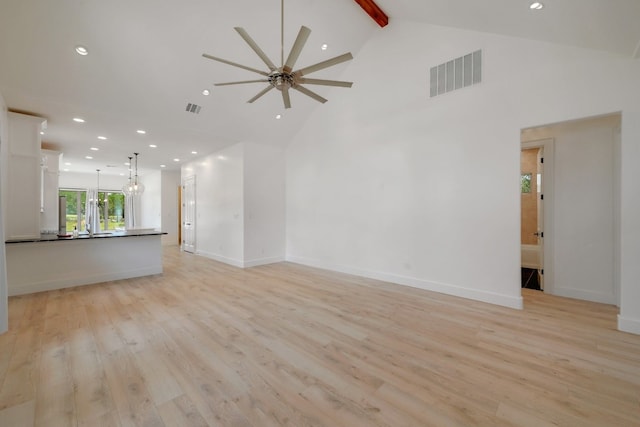 unfurnished living room with high vaulted ceiling, beamed ceiling, light wood-type flooring, and ceiling fan with notable chandelier